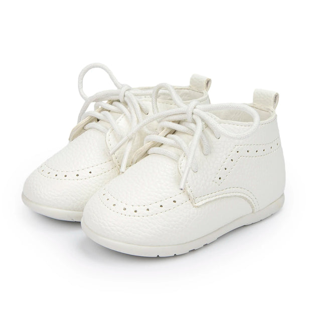 Pair of white baby shoes on a white background