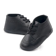 Pair of black leather shoes with laces on a white background
