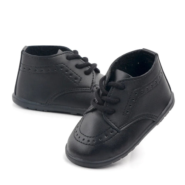 Pair of black leather shoes with laces on a white background