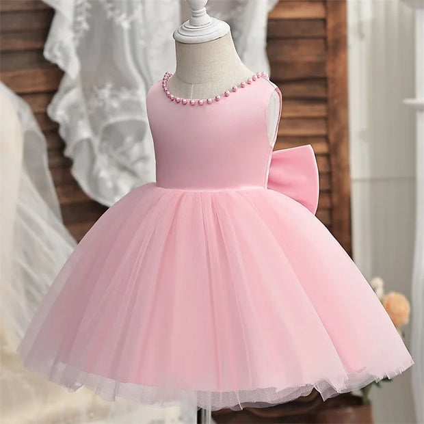 Pink dress with a bow on a mannequin against a blurred background
