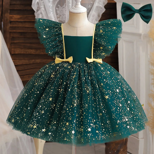 Green dress with star patterns on a mannequin, accompanied by a green bow.