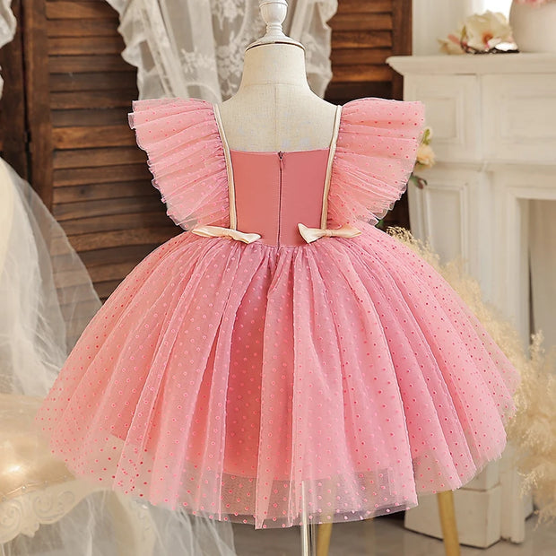 Pink tulle dress on a mannequin against a decorative background