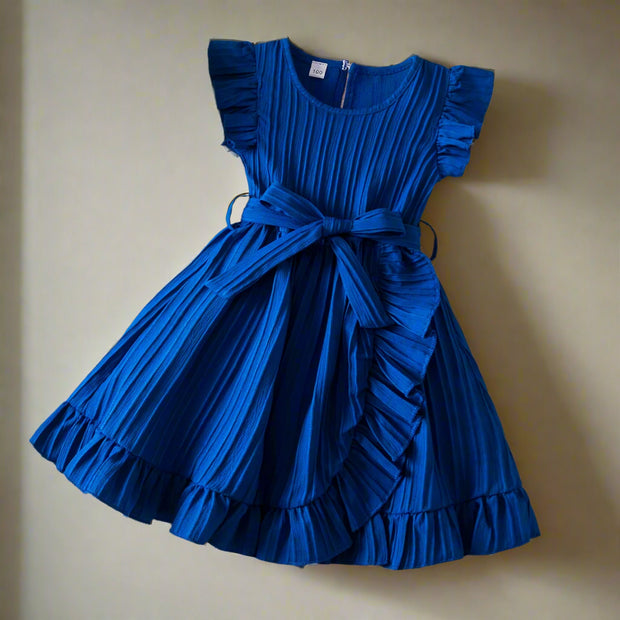 Blue dress with ruffled details on a textured surface with decorative items.