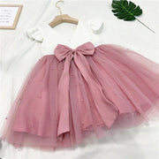 Pink tutu skirt with a bow on a white background