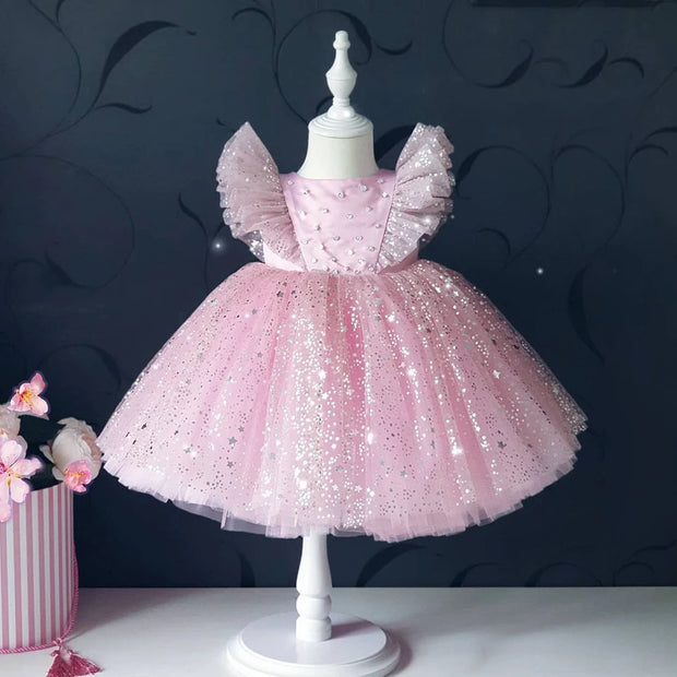 Pink sequined dress on a mannequin against a dark background