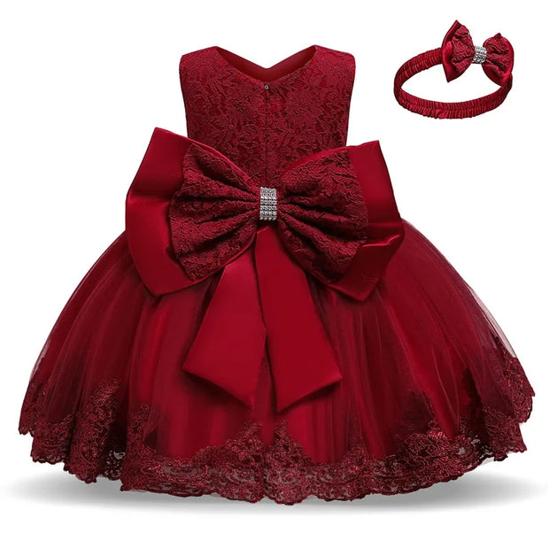 Red lace dress with a large bow and matching headband on a white background