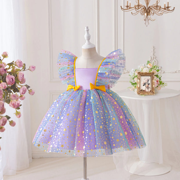 Children's dress with star pattern on a mannequin in a decorated room.