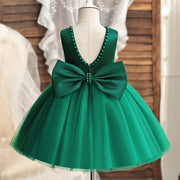 Green dress with a large bow on a mannequin against a neutral background