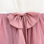 Close-up of a pink tulle skirt with a large bow on a white background