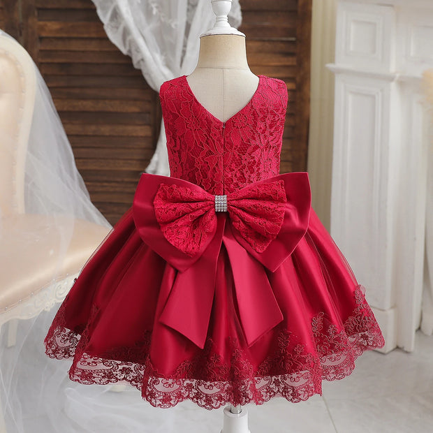 Red lace dress with a large bow on a mannequin against a neutral background