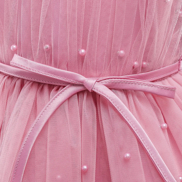 Close-up of a pink dress with a belt and pearl embellishments