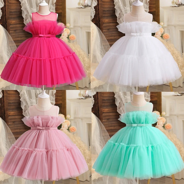 Four colorful dresses on mannequins against a neutral background