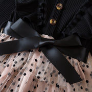 Black ribbed sweater with a black bow and polka dot skirt