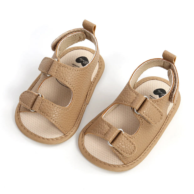 Pair of tan baby sandals on a white background