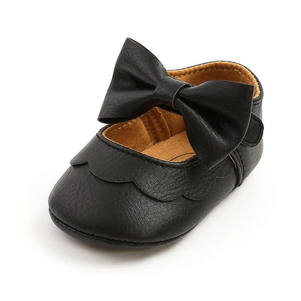 Black baby shoe with a bow on a white background