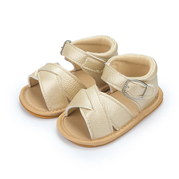 Pair of gold sandals with buckles on a white background