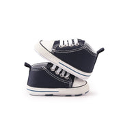 Pair of navy blue high-top sneakers with white soles on a white background