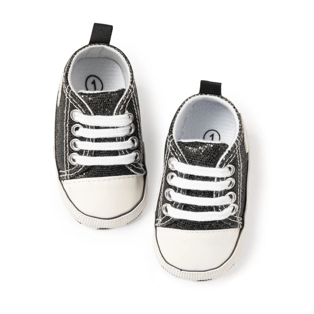 Pair of black and white baby sneakers on a white background