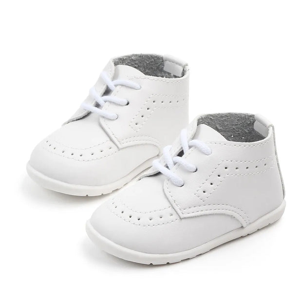 White baby shoes with gray soles on a white background
