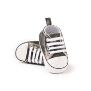 Pair of baby sneakers with white laces on a white background