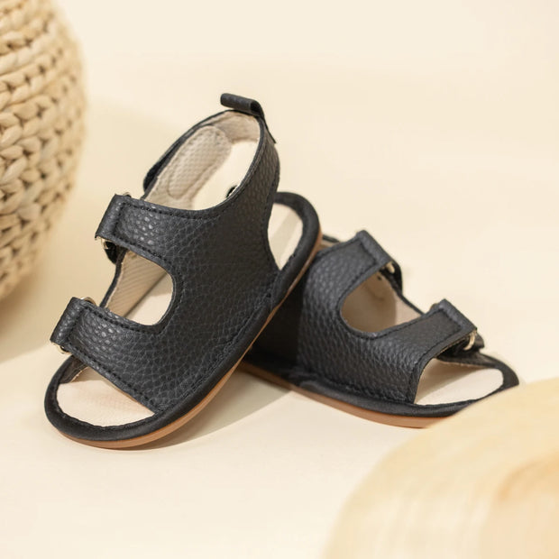 Pair of black sandals on a beige background