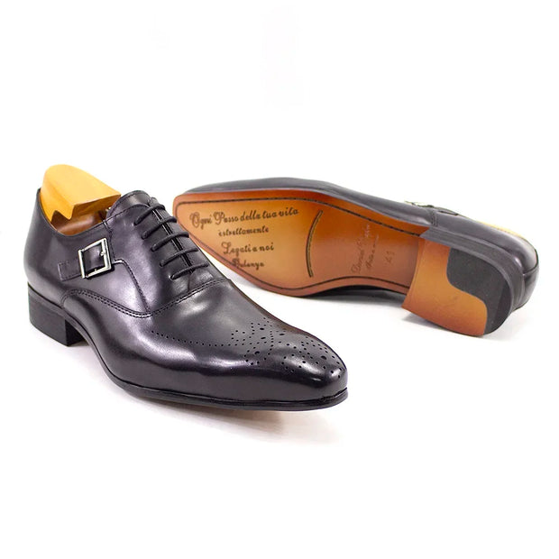 Black dress shoe with brown sole on a white background