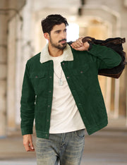 Man wearing a green jacket with a white shirt and jeans, holding a brown leather bag.