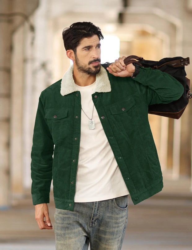 Man wearing a green jacket with a white shirt and jeans, holding a brown leather bag.