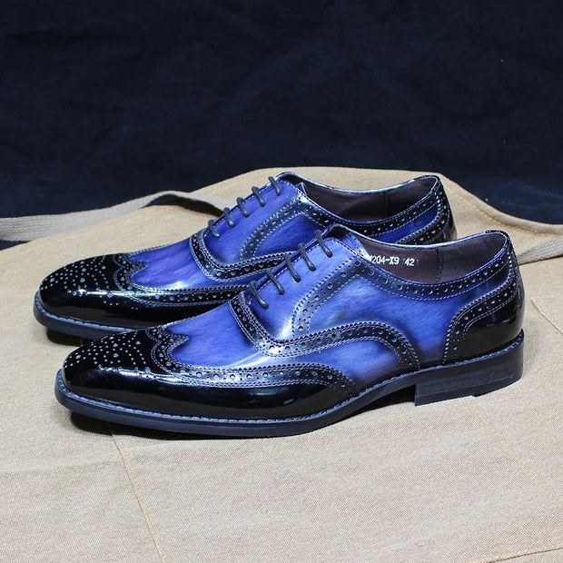 Pair of blue dress shoes on a textured surface with a dark background