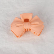 Peach-colored bow-shaped object on a white background