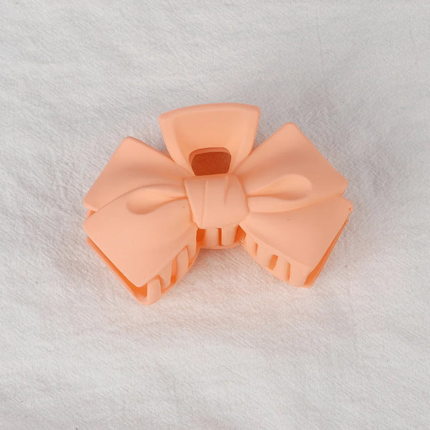 Peach-colored bow-shaped object on a white background