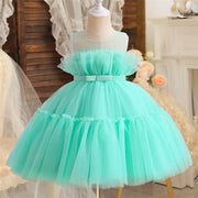 Mint green tulle dress on a mannequin against a decorative background