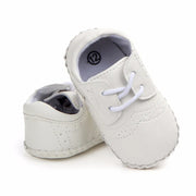 White baby shoes with soft soles on a white background