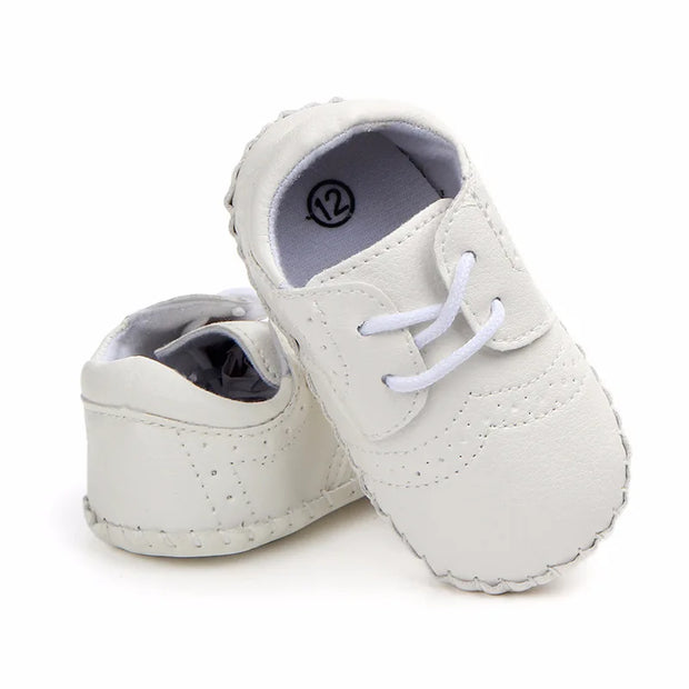 White baby shoes with soft soles on a white background