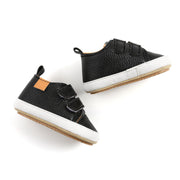 Pair of black children's shoes with white soles on a white background