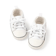 Pair of white baby sneakers on a white background