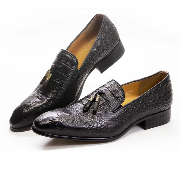 Black crocodile-patterned loafers with tassels on a white background