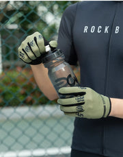 Person wearing gloves holding a clear water bottle with a blurred background