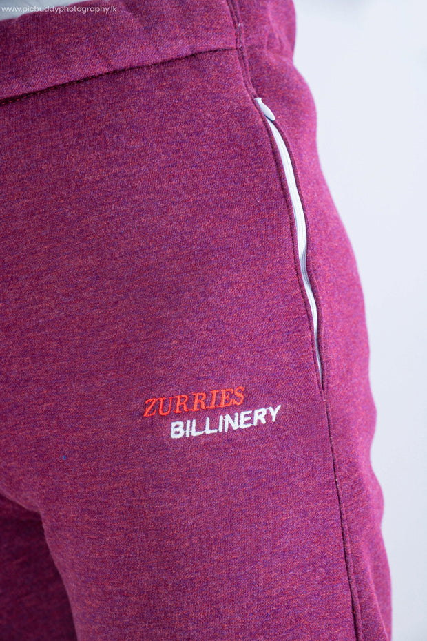 Close-up of a maroon garment with 'Zurries Billinery' branding on a white background