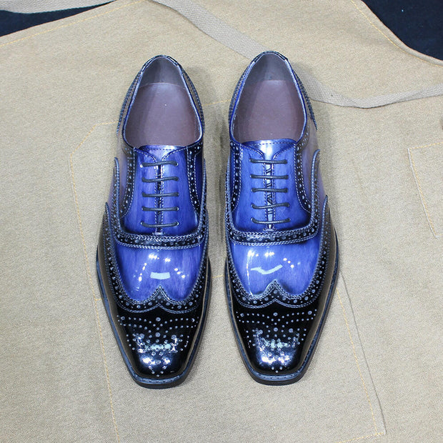 Pair of blue and black dress shoes on a beige fabric background