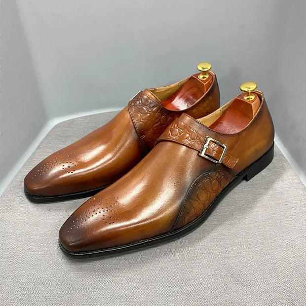 Pair of brown leather shoes with a buckle on a gray background