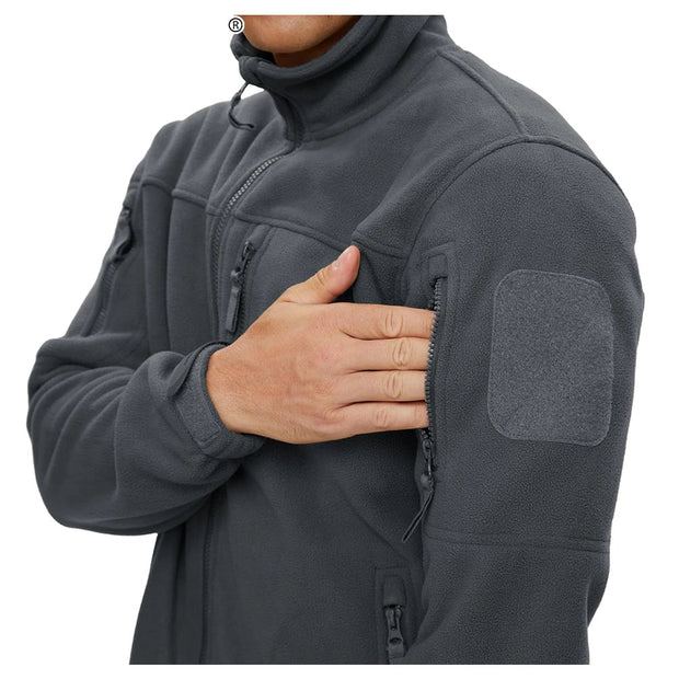 Person wearing a gray tactical jacket with a visible brand logo on a white background