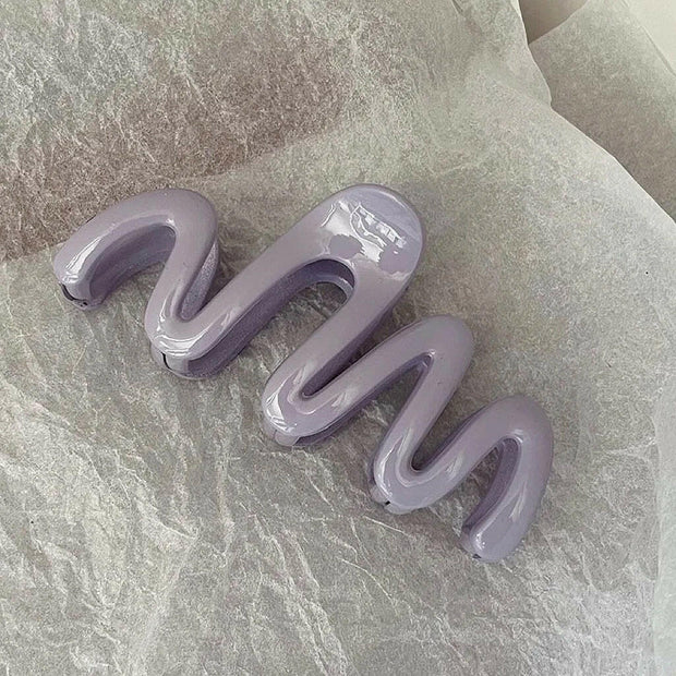 Purple spiral object on a textured gray surface