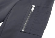 Close-up of a dark gray jacket with a zipper pocket on a white background