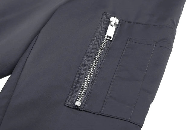 Close-up of a dark gray jacket with a zipper pocket on a white background
