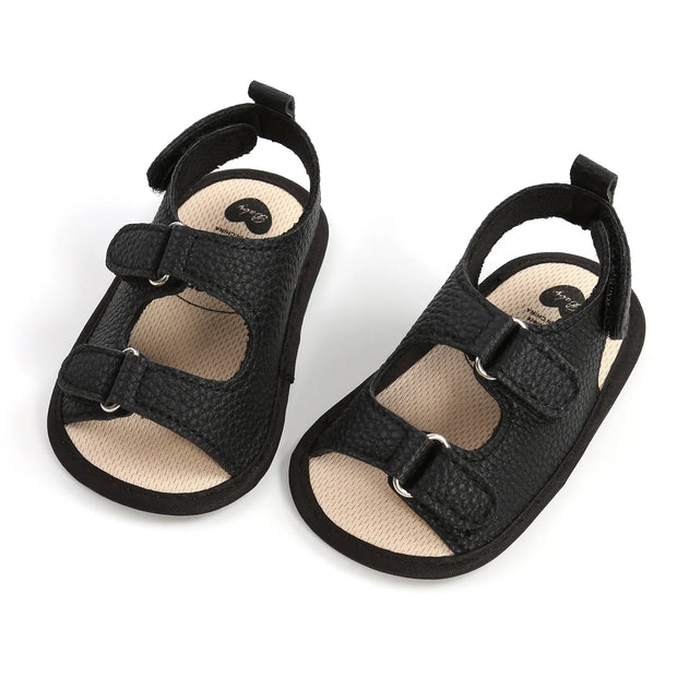 Pair of black baby sandals on a white background