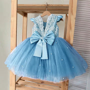 Blue dress with lace top and large bow on a wooden hanger