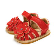 Red children's sandals with floral designs on a white background