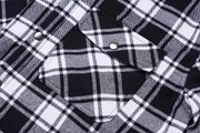 Close-up of a black and white plaid shirt with buttons.