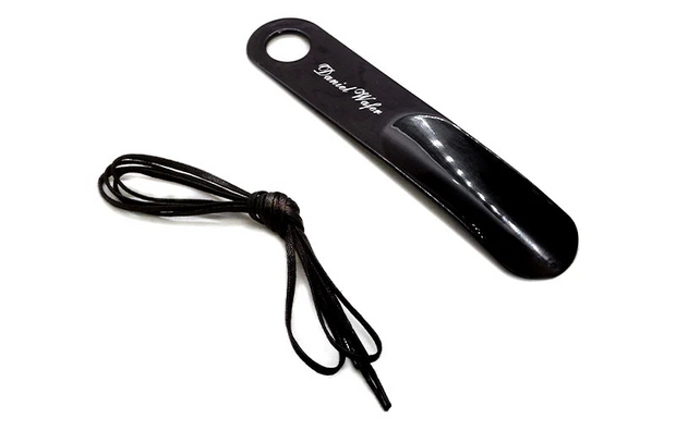Black shoehorn with a cord on a white background